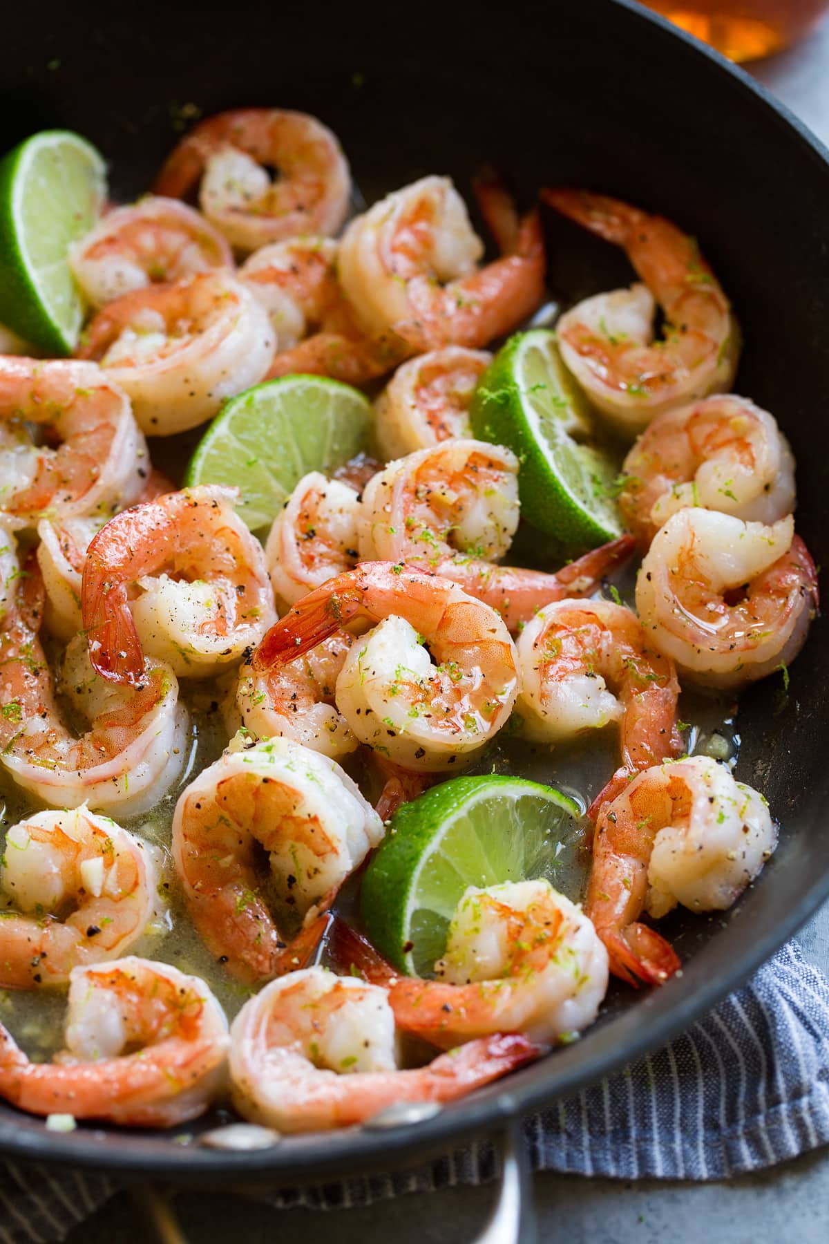 Shrimp with Honey Lime Sauce (Only 5 Ingredients!) Close up image of shrimp with honey lime sauce in a black skillet.