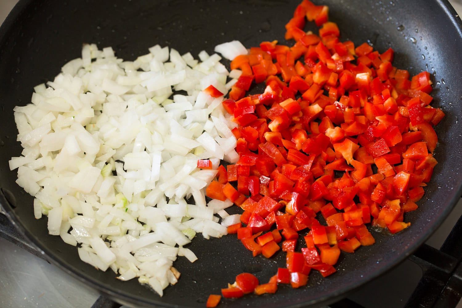 Sloppy Joes Red bell pepper and yellow onion added to a black skillet.