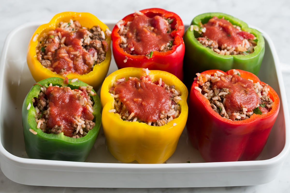 Stuffed Peppers Stuffing par cooked bell peppers in baking dish with rice and ground beef filling.