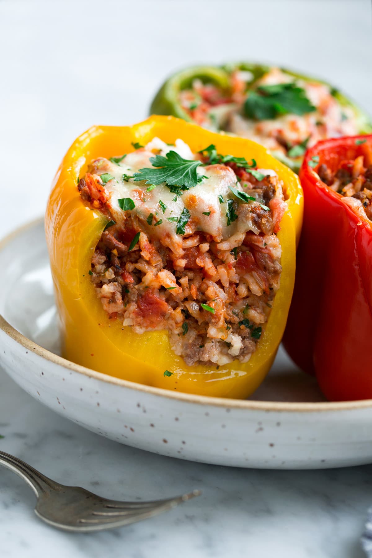 Stuffed Peppers Stuffed Bell Peppers cut in half to show filling including ground beef, rice, tomato sauce and cheese.