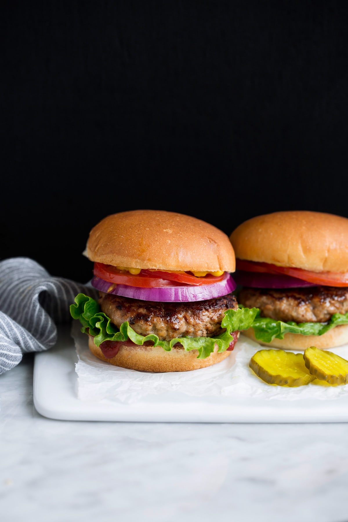 Turkey Burgers Two turkey burgers on a white serving platter.