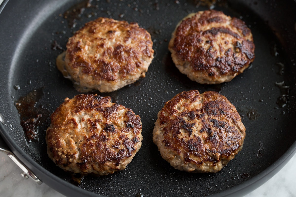 Turkey Burgers Four turkey burger patties in a large black skillet.