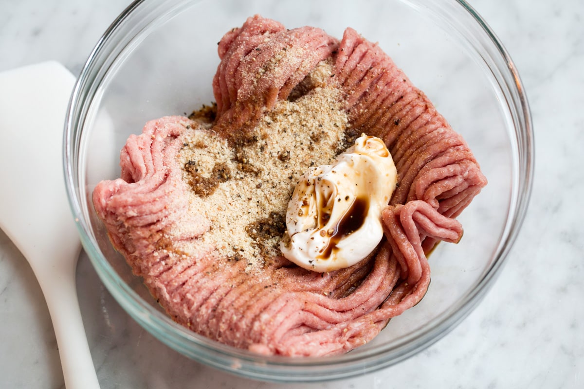 Turkey Burgers Showing how to make turkey burgers, mixing turkey burger patty mixture in a glass mixing bowl.