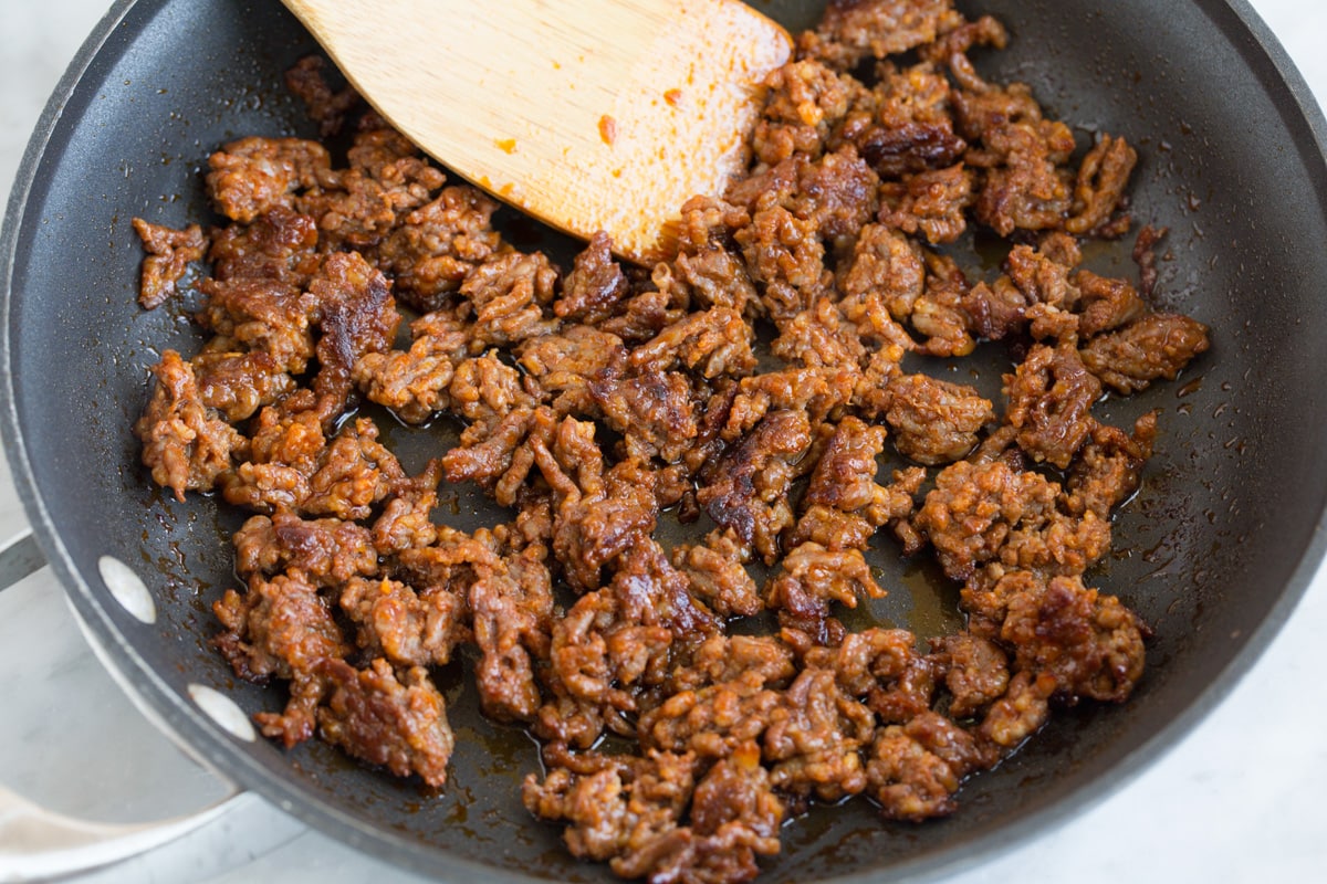 Breakfast Burritos sauteeing chorizo in a skillet until browned