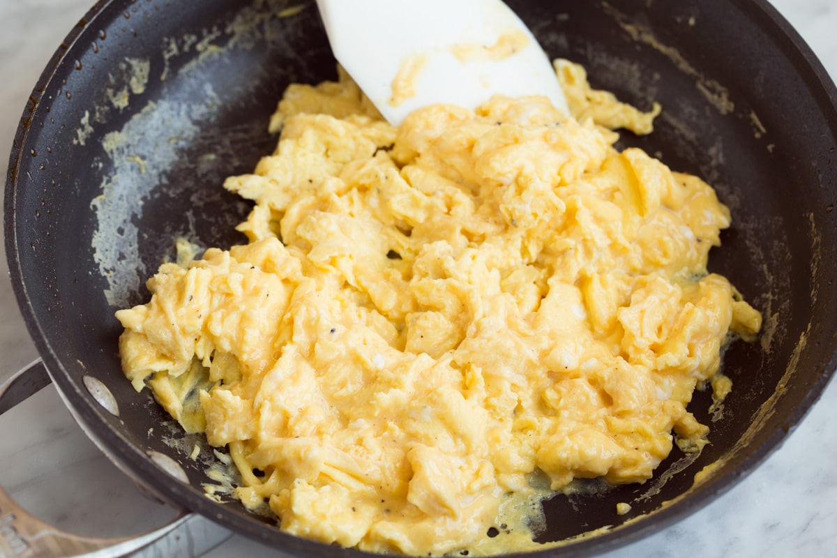 Breakfast Burritos cooking scrambled eggs in a skillet