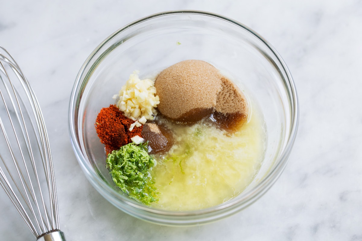 Brown Sugar Lime Baked Salmon Showing how to make sauce for baked salmon. Mixing melted butter, brown sugar, lime, garlic, cayenne pepper in a small mixing bowl.