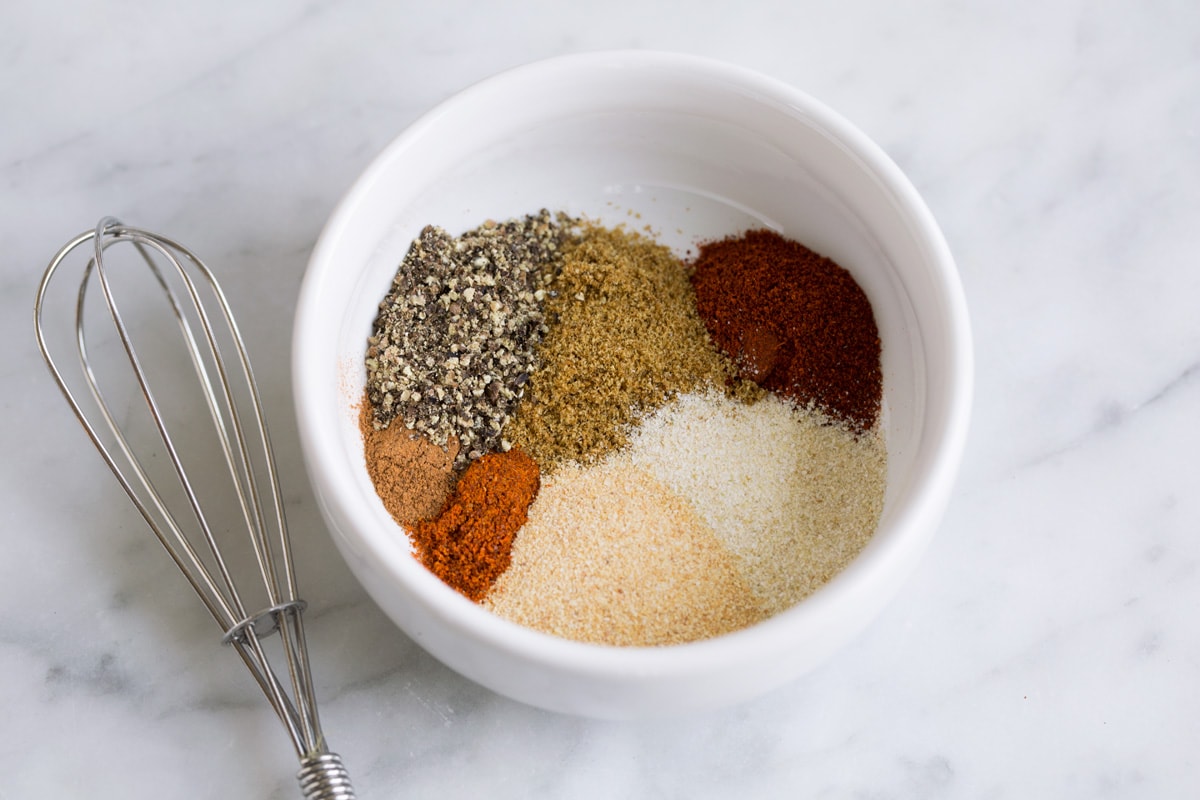 Grilled Pork Chops pork chop seasoning in white bowl next to whisk