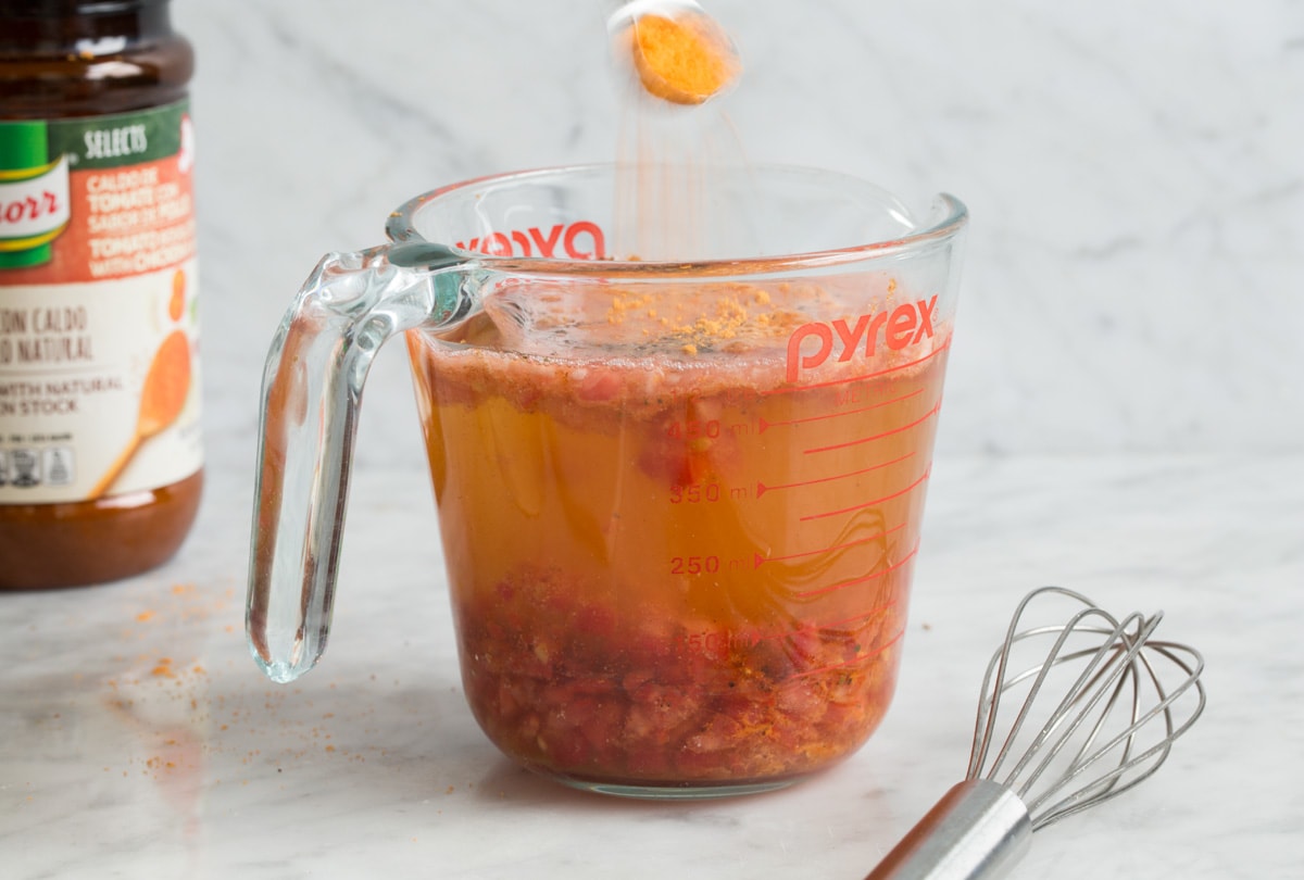 Mexican Rice Showing how to make mexican rice. Mixing liquid ingredients and seasonings in a liquid measuring cup.