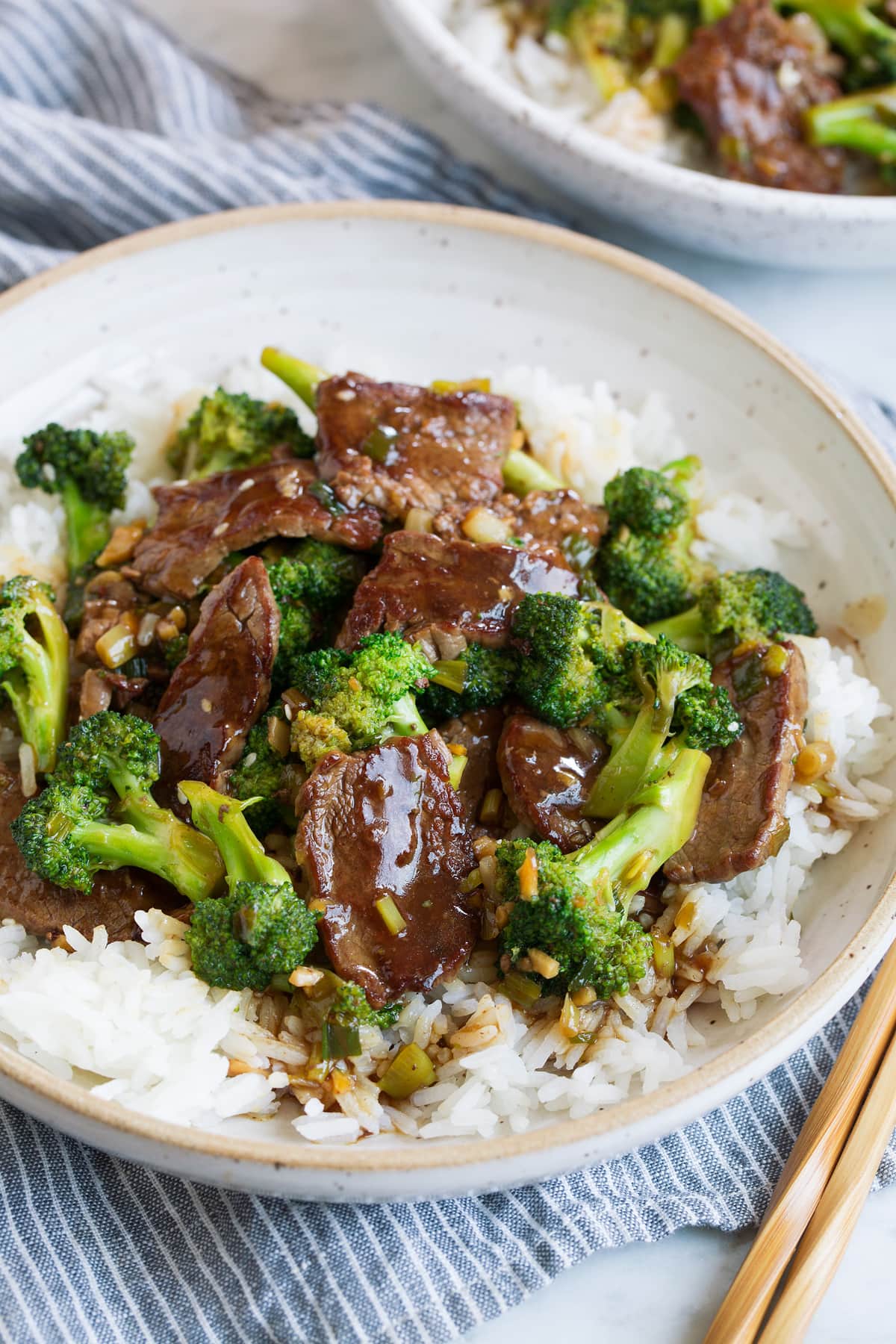 Beef and Broccoli - this is a staple dinner recipe! Easy, flavorful and sure to satisfy! #beef #broccoli #chinese #recipe Beef and broccoli over white rice in a bowl.