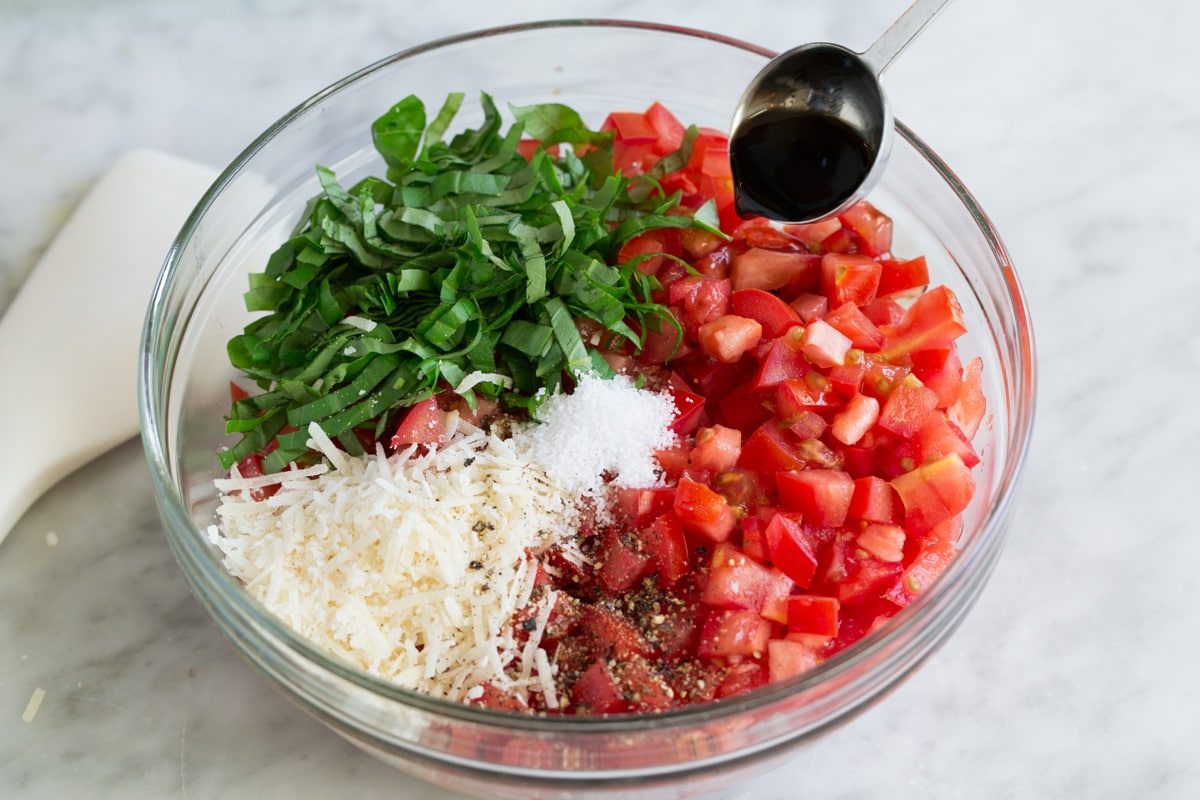 Fresh Bruschetta Bruschetta ingredients in a glass mixing bowl before mixing