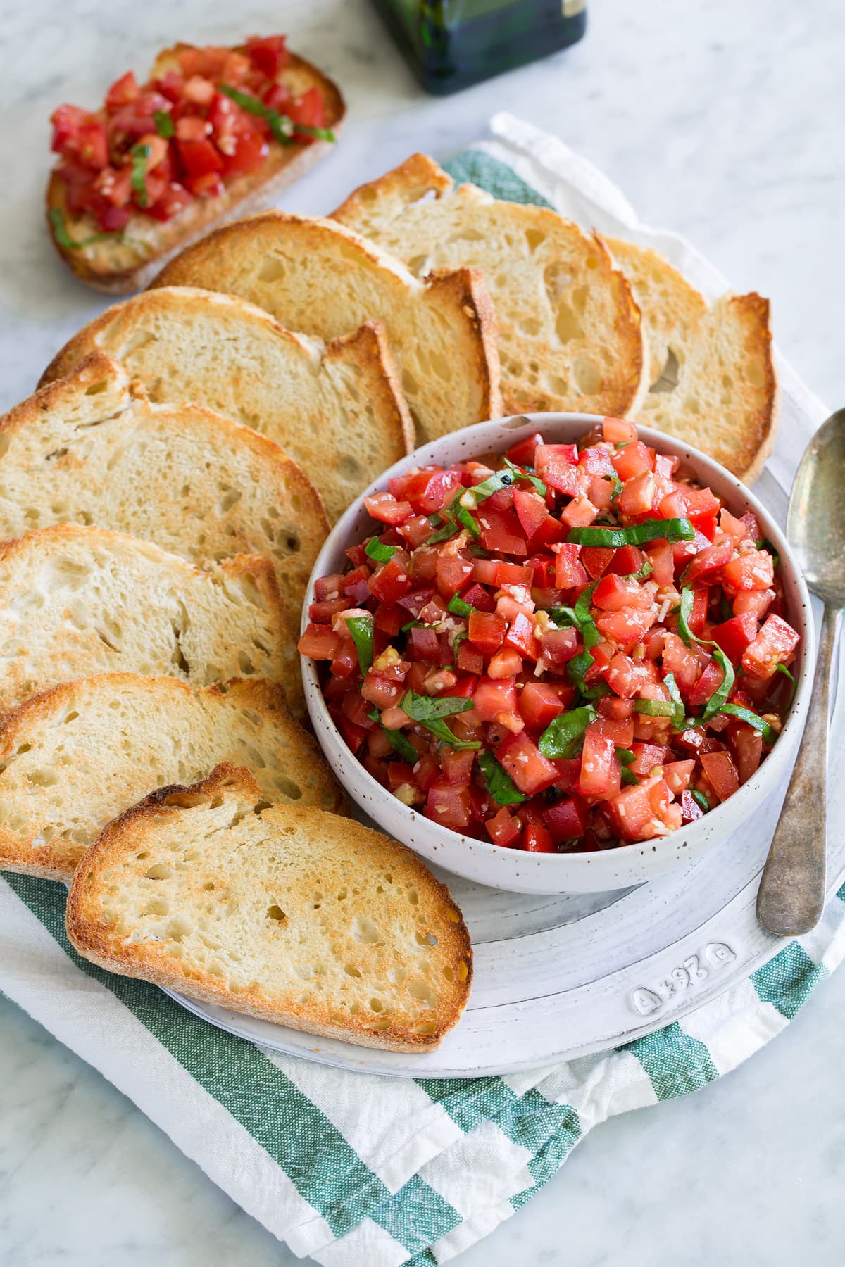 Fresh Bruschetta Tomato Bruschetta topping in a white serving bowl with toasted French bread on the side