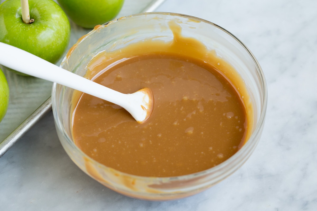 Easy Caramel Apples melted caramel in a glass mixing bowl.