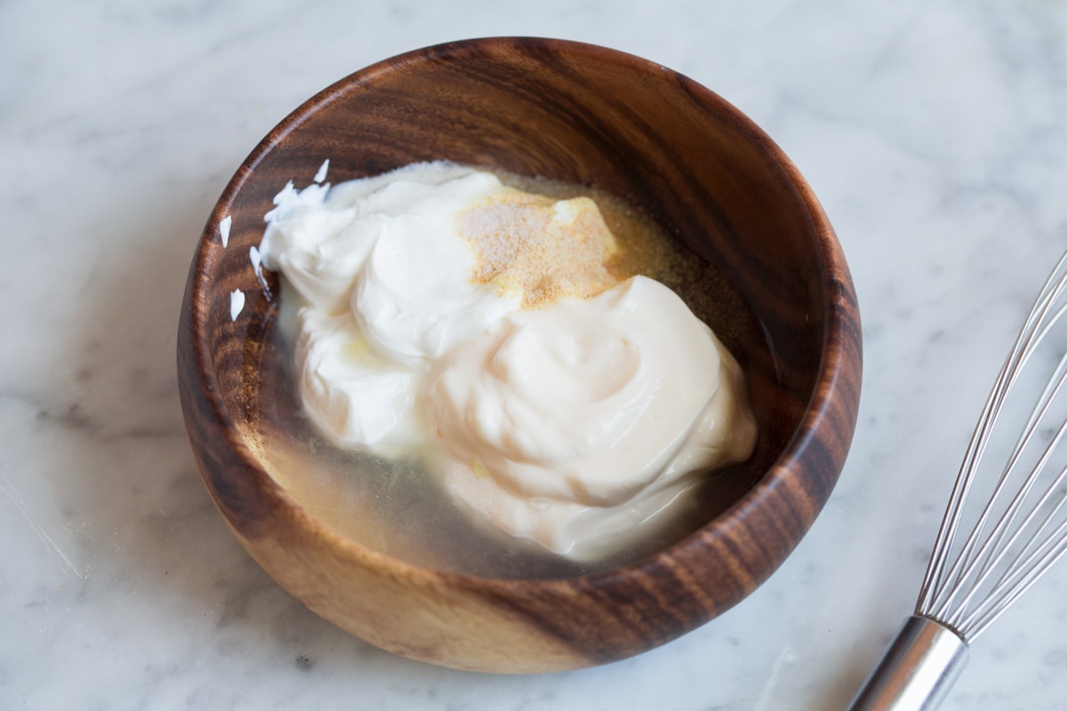 Fish Tacos - these are unbelievably delicious! Easy to make too! Includes directions for oven or grill - you'll love both, just don't omit the sauce! #fishtacos #tacos #fish #recipe Fish taco sauce ingredients in a wooden bowl before mixing.