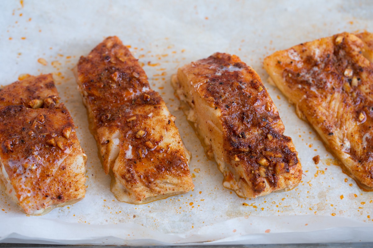 Fish Tacos - these are unbelievably delicious! Easy to make too! Includes directions for oven or grill - you'll love both, just don't omit the sauce! #fishtacos #tacos #fish #recipe Mexican seasoned fish fillets on a baking sheet after baking.