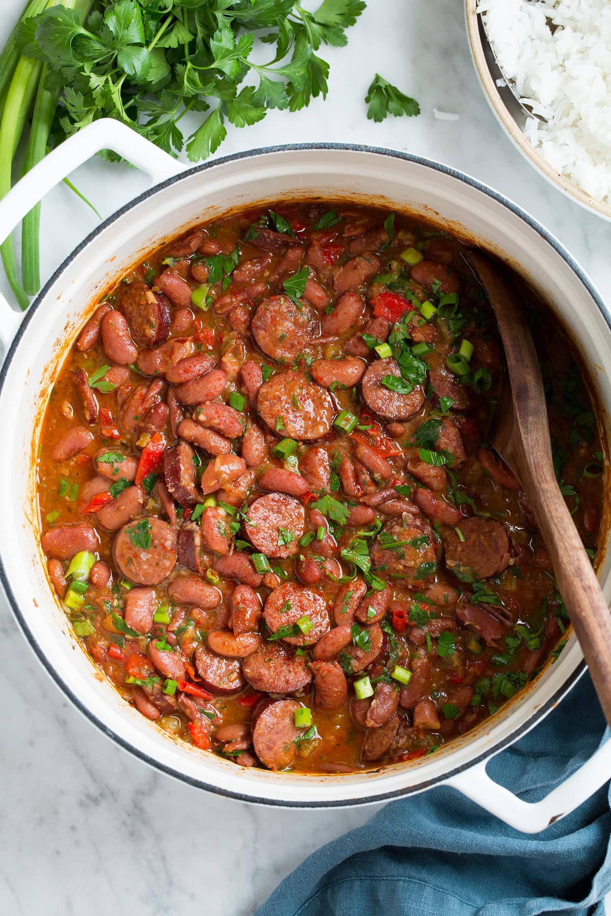 Perfect Red Beans and Rice - delicious Louisiana style comfort food at it's best! #redbeans #rice #southern #recipe #dinner Overhead image of pot full of red beans and sausage with a side of rice on the side.