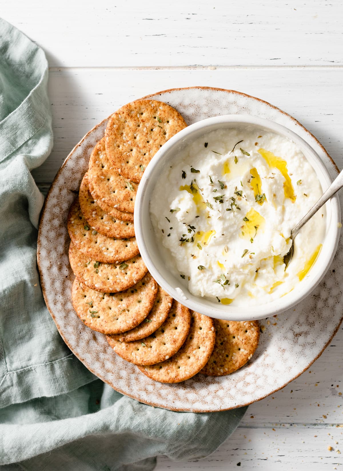 Homemade Ricotta Cheese - the BEST ricotta you'll try! It's so much better than store bought and incredibly easy to make! It's delicious in savory and sweet dishes and you can use the leftovers for toast. #ricotta #cheese #recipe #homemade #italianrecipes Easy homemade ricotta in a bowl with a side of crackers.