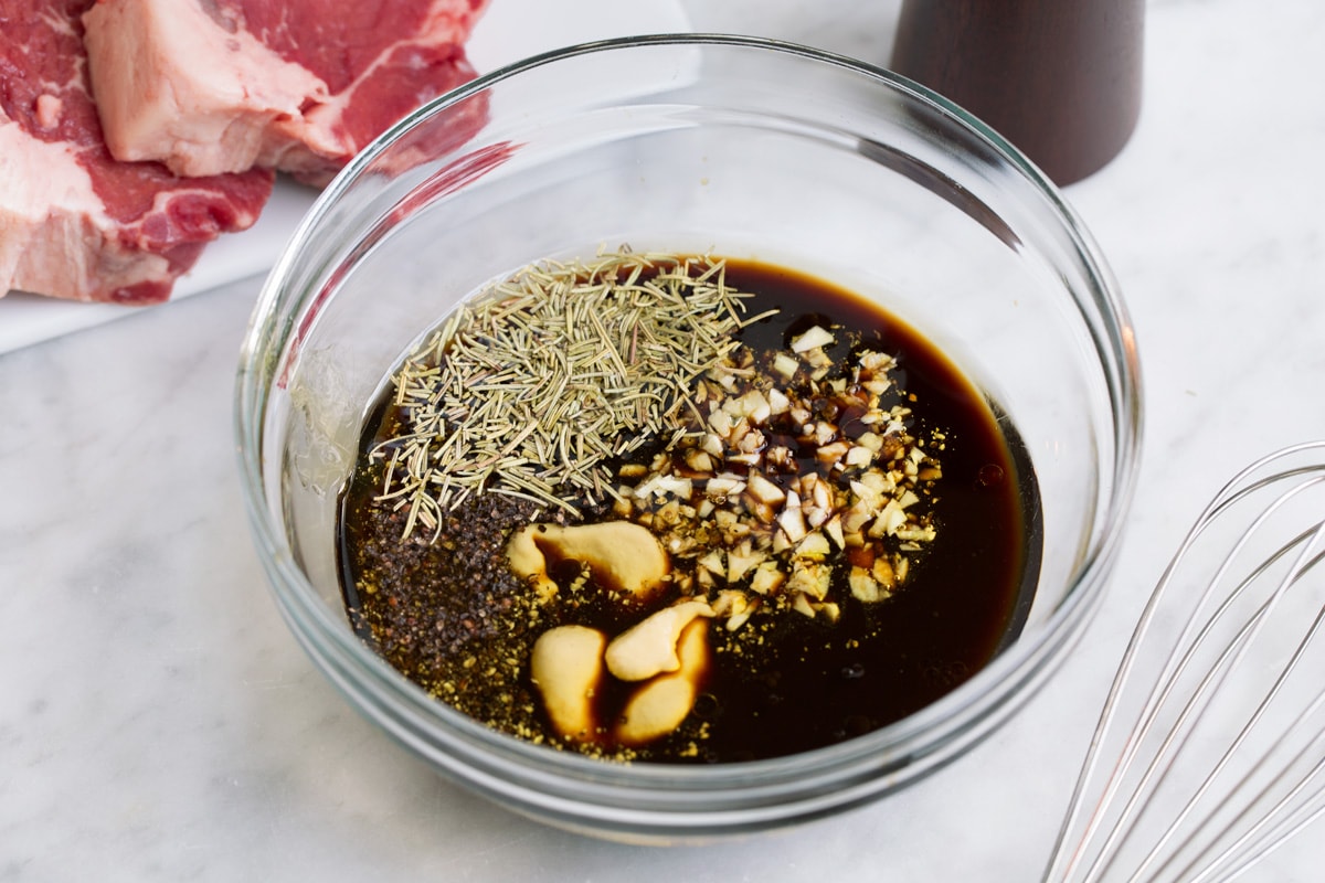 The BEST Steak Marinade! Made with balsamic vinegar and a handful of other pantry staples. A summer must have recipe! #steak #marinade Showing how to make steak marinade. Mixing ingredients in a glass mixing bowl.
