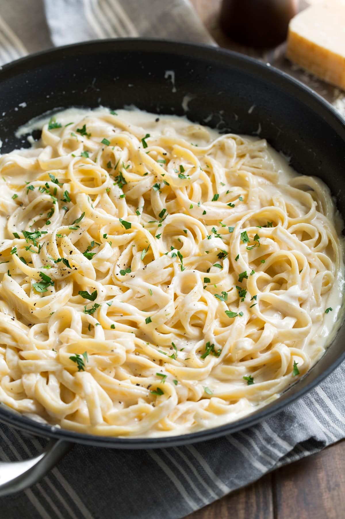 Best Alfredo Sauce - made with half milk and half cream so it's not too heavy, and includes plenty of parmesan for incredible flavor! So easy and seriously delicious! #alfredosauce #alfredo #fettuccinealfredo #dinner #pasta Fettuccine alfredo in a large pan.