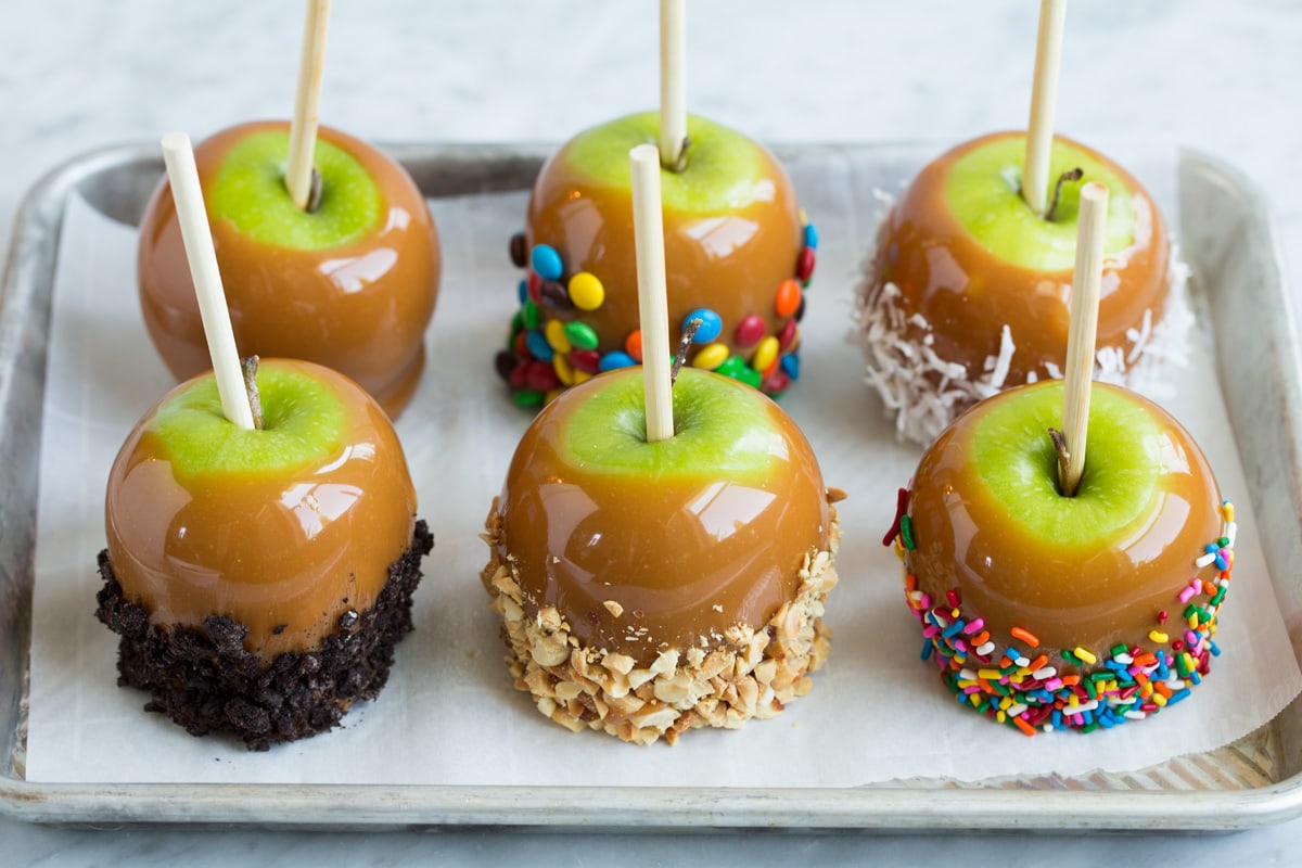 Easy Caramel Apples Six caramel apples on a baking sheet lined with parchment paper.