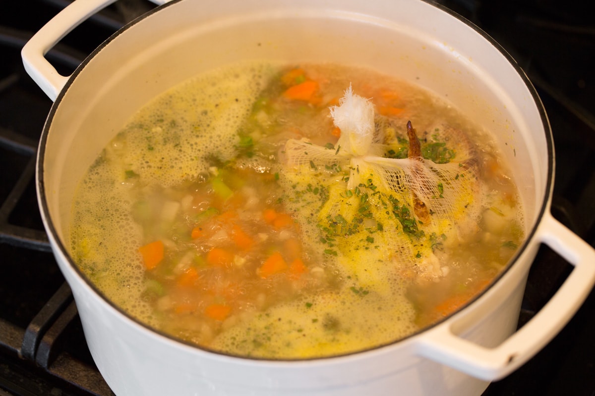 The BEST Quick and Easy Chicken Noodle Soup! This has been my go-to recipe for years. So easy and everyone always loves it! #chickennoodle #soup #dinner #chicken Simmering chicken noodle soup on stove top.