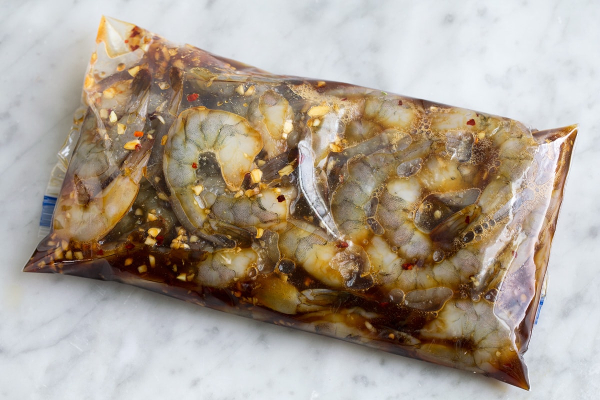 Grilled Shrimp with Honey Garlic Marinade - only 4 ingredients in this fast, easy and flavorful marinade! Perfect for a quick dinner! #shrimp #marinade #grilledshrimp #dinner #recipe Shrimp in marinade in a plastic resealable bag.