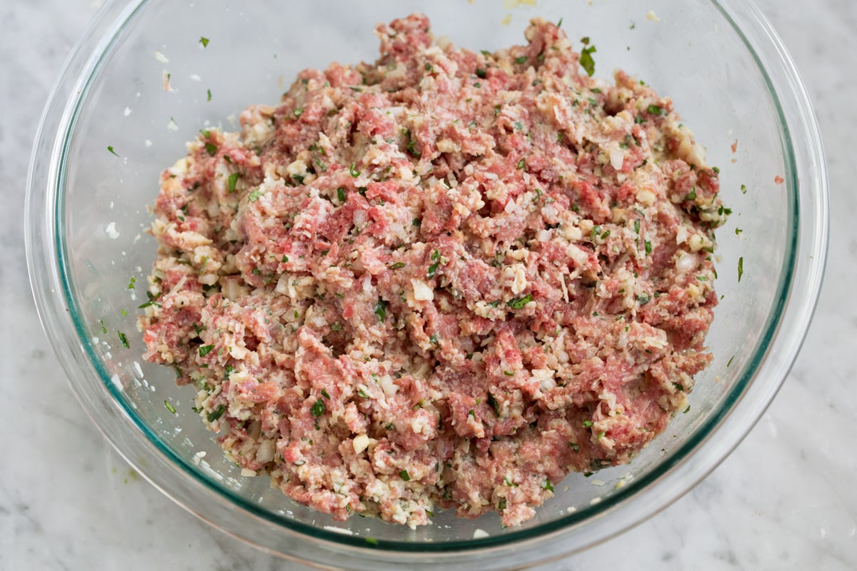 BEST MEATBALLS - these are so flavorful, so tender and packed with fresh ingredients! Makes the best spaghetti and meatballs ever! #meatballs #spaghetti #italian #dinner #groundbeef #pork #recipe Mixed raw meatball mixture in a glass mixing bowl.