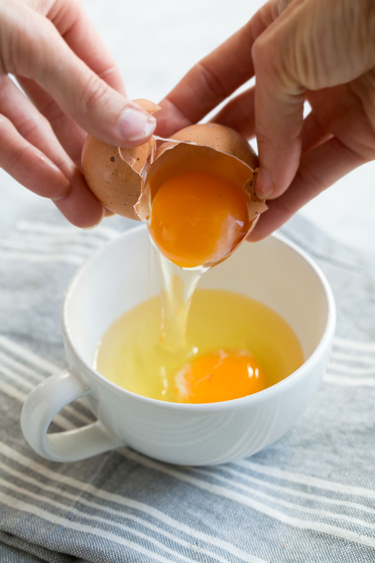 Microwave Eggs cracking egg into a mug