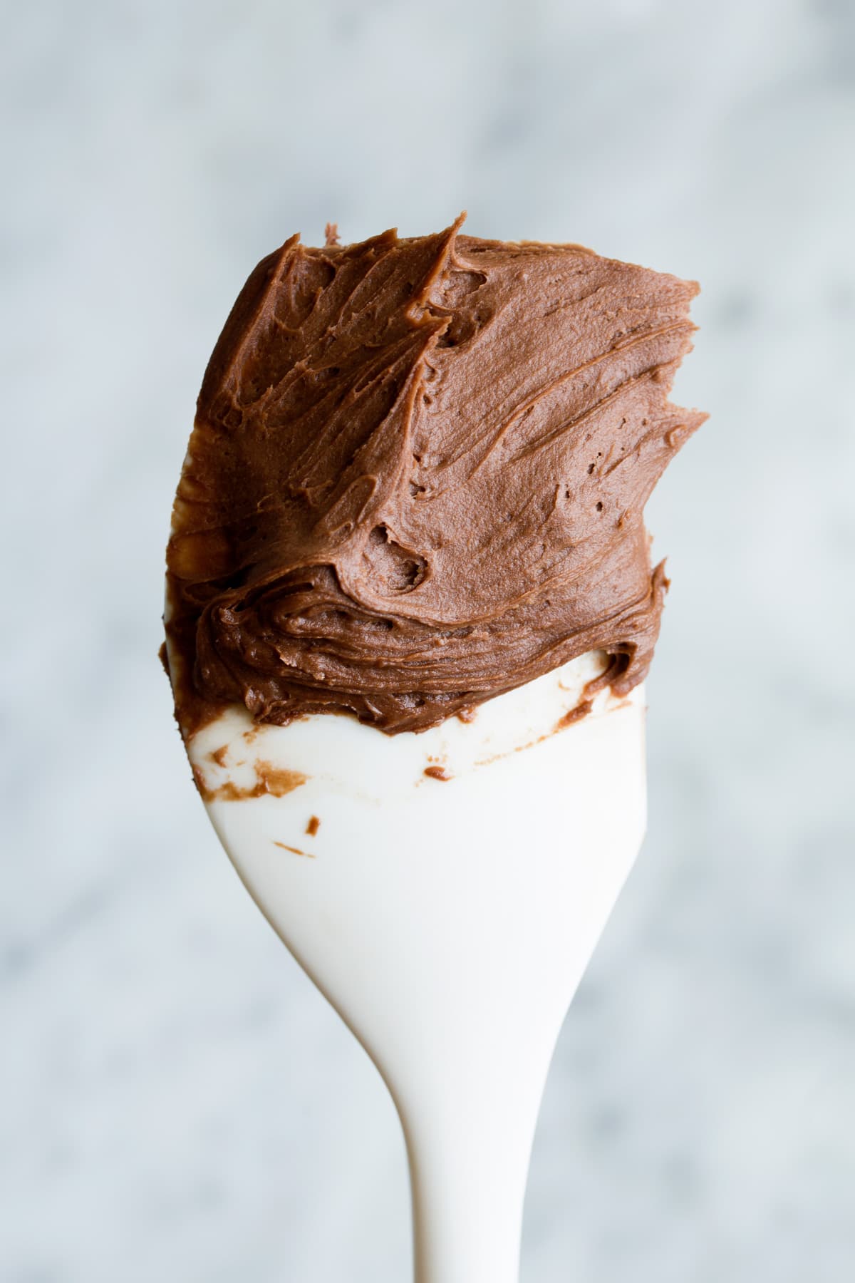 BEST Chocolate Buttercream Frosting - rich, creamy, fluffy, smooth and perfectly decadent! #chocolate #buttercream #frosting #cake Chocolate frosting on a spatula