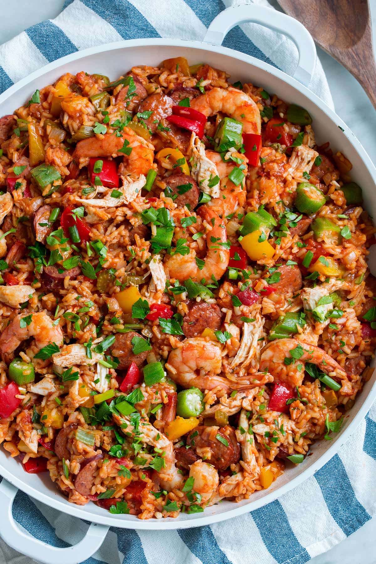 Jambalaya - super hearty and flavorful! Made with sausage, shrimp, chicken, rice, lots of vegetables and a delicious seasoning blend! Love that it's made in one pan. #jambalaya #cajun #southern #recipe Overhead image of a large paella pan full of jambalaya.