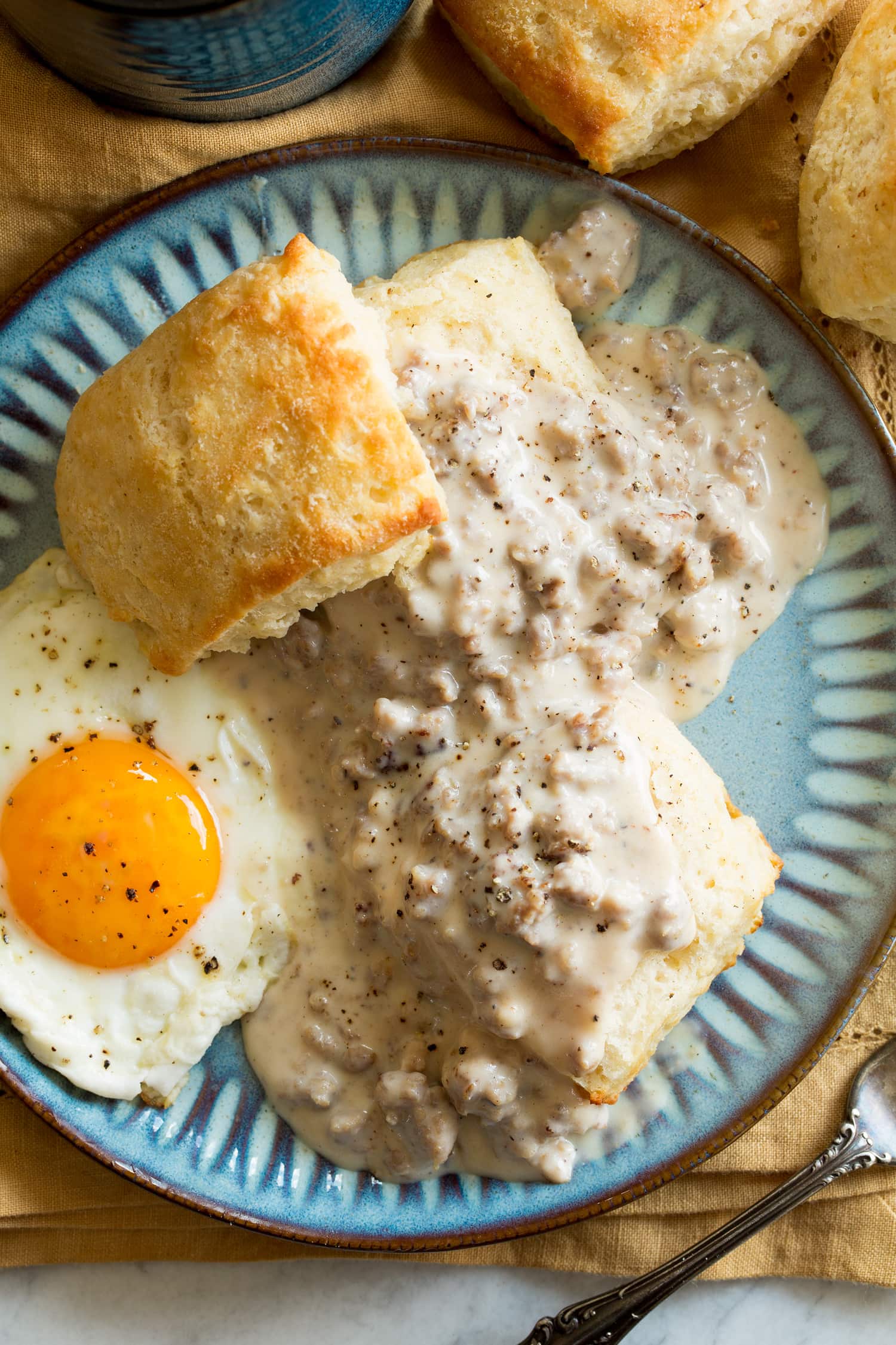 Biscuits and Sausage Gravy Biscuits and gravy served with a sunny side egg as a serving suggestion.