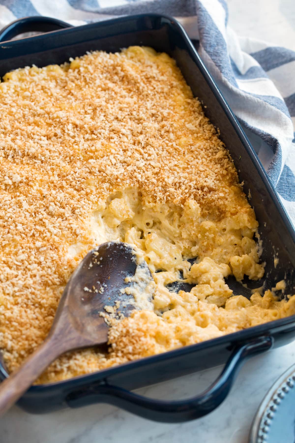 Baked Macaroni and Cheese Baked macaroni in a casserole dish with a few scoops removed to show creamy cheesy macaroni noodles.