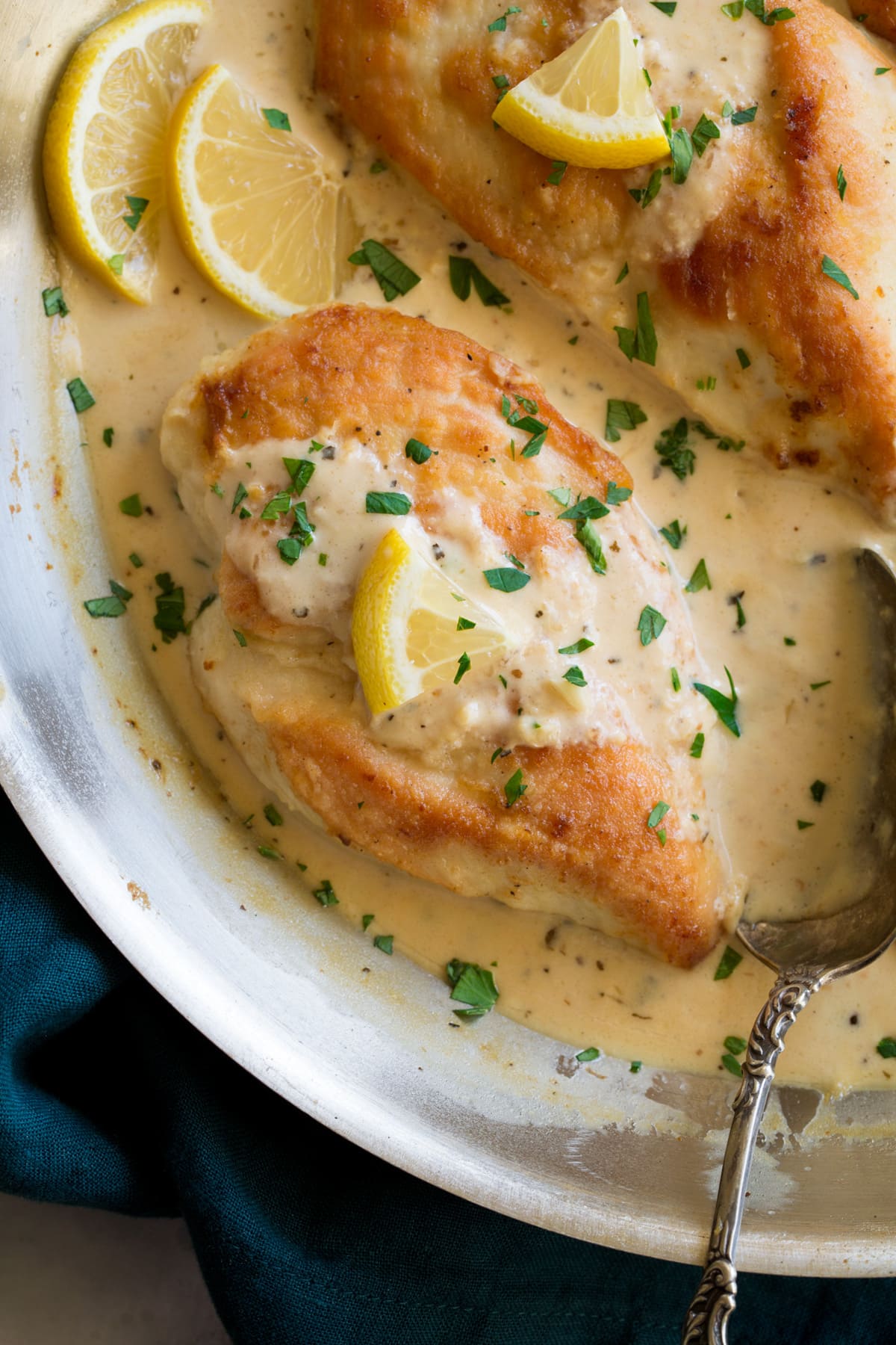 Creamy Lemon Romano Chicken Close up image of chicken breasts in pan in a creamy lemon romano sauce.
