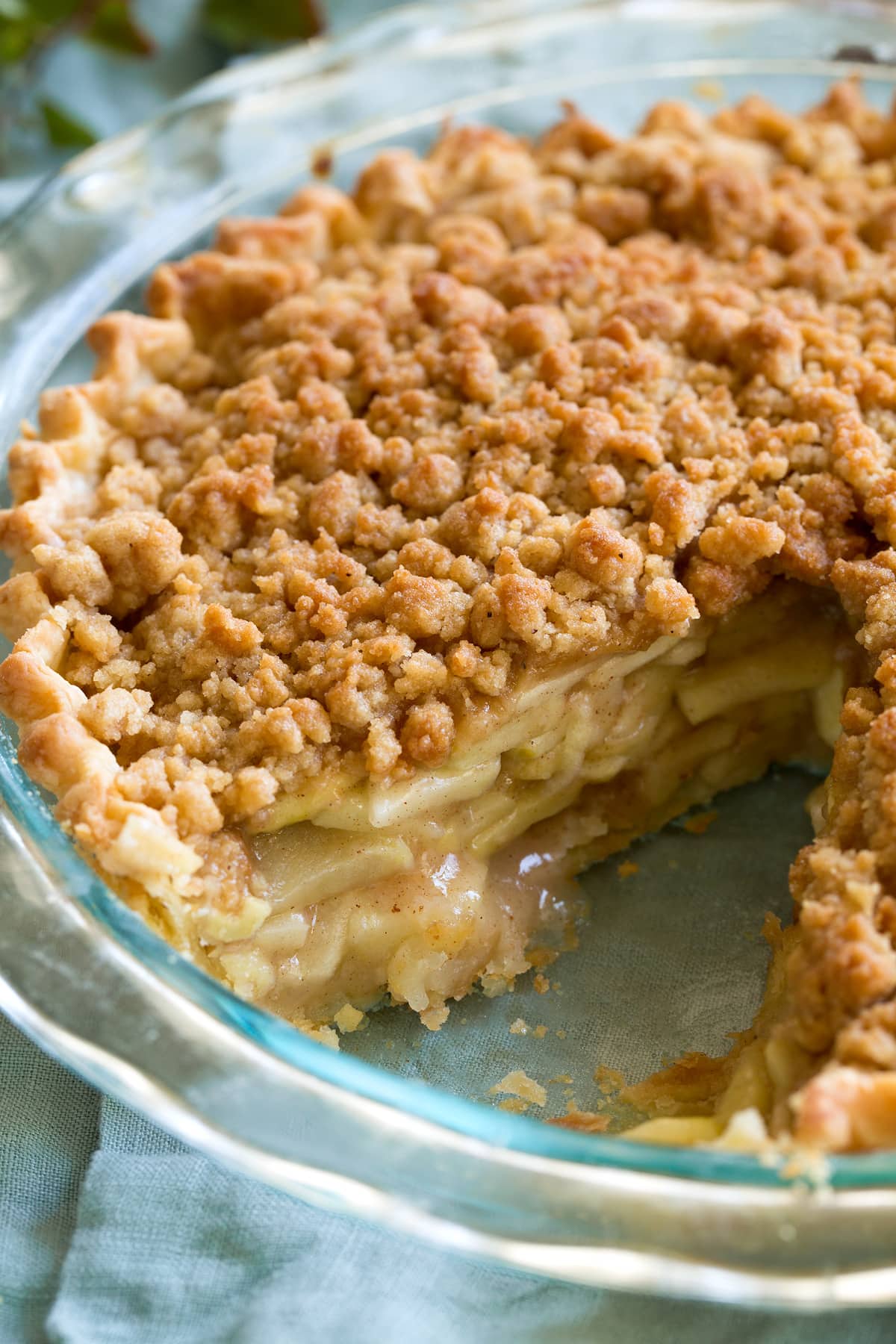 Dutch Apple Pie - my favorite pie! Made with flakey buttery pie crust, sweet, spiced apple filling and a delicious crumb topping. #applepie #pie #dutchapple #thanksgiving #dessert Close up image of Dutch apple pie in a glass pie pan.