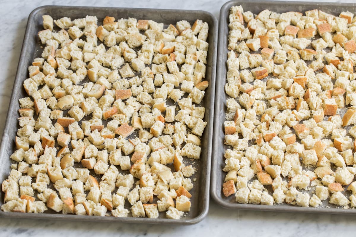Stuffing Recipe - this is my FAVORITE stuffing! It's perfectly moistened in the center, browned and crisp on the edges and packed with butter and herb flavor. A fall staple! #stuffing #thanksgiving #sidedish #recipe Bread cubes on a baking dish after drying in the oven.