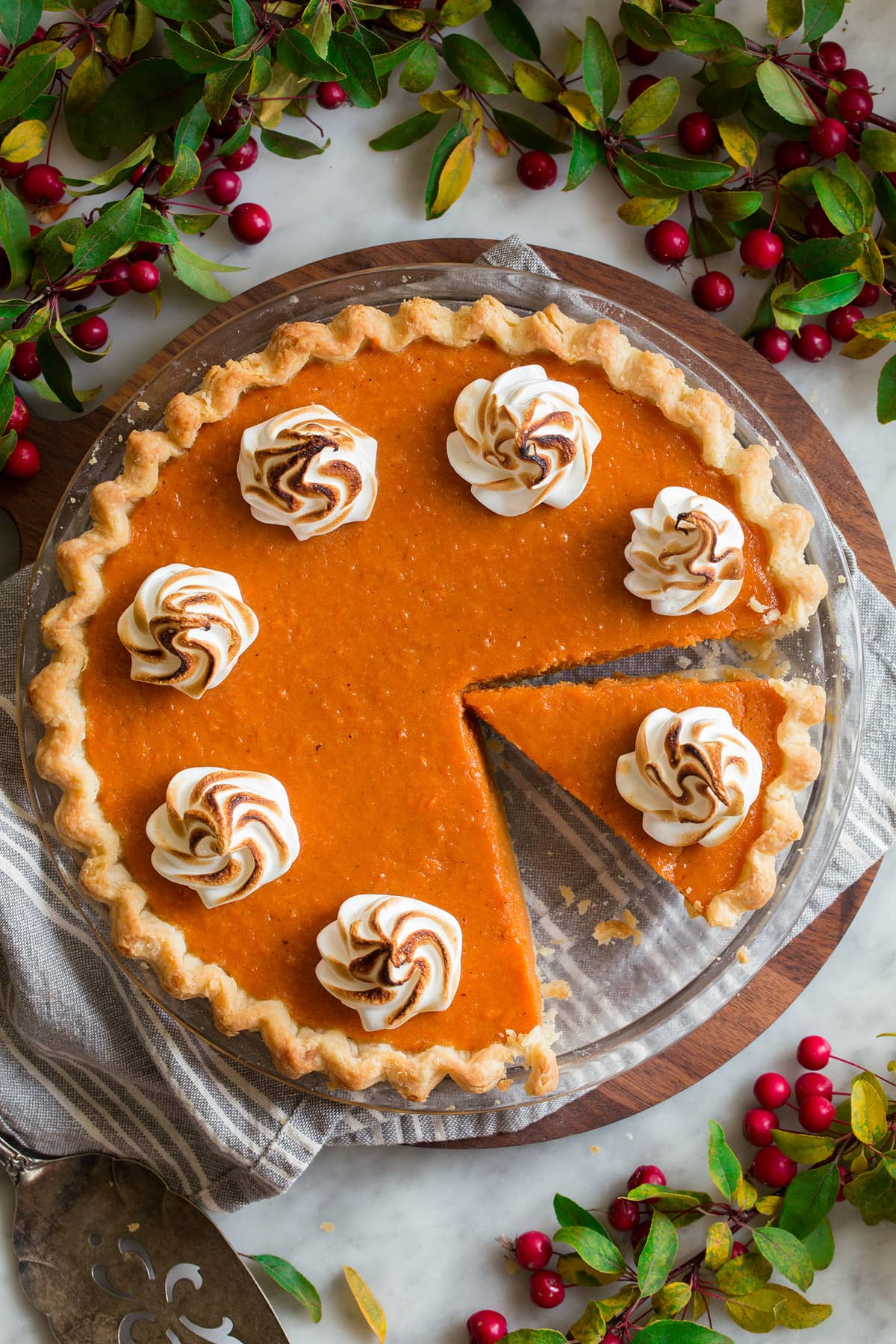Perfect Sweet Potato Pie Overhead image of sweet potato pie with a slice cut. Pie is topped with marshmallow swirls.