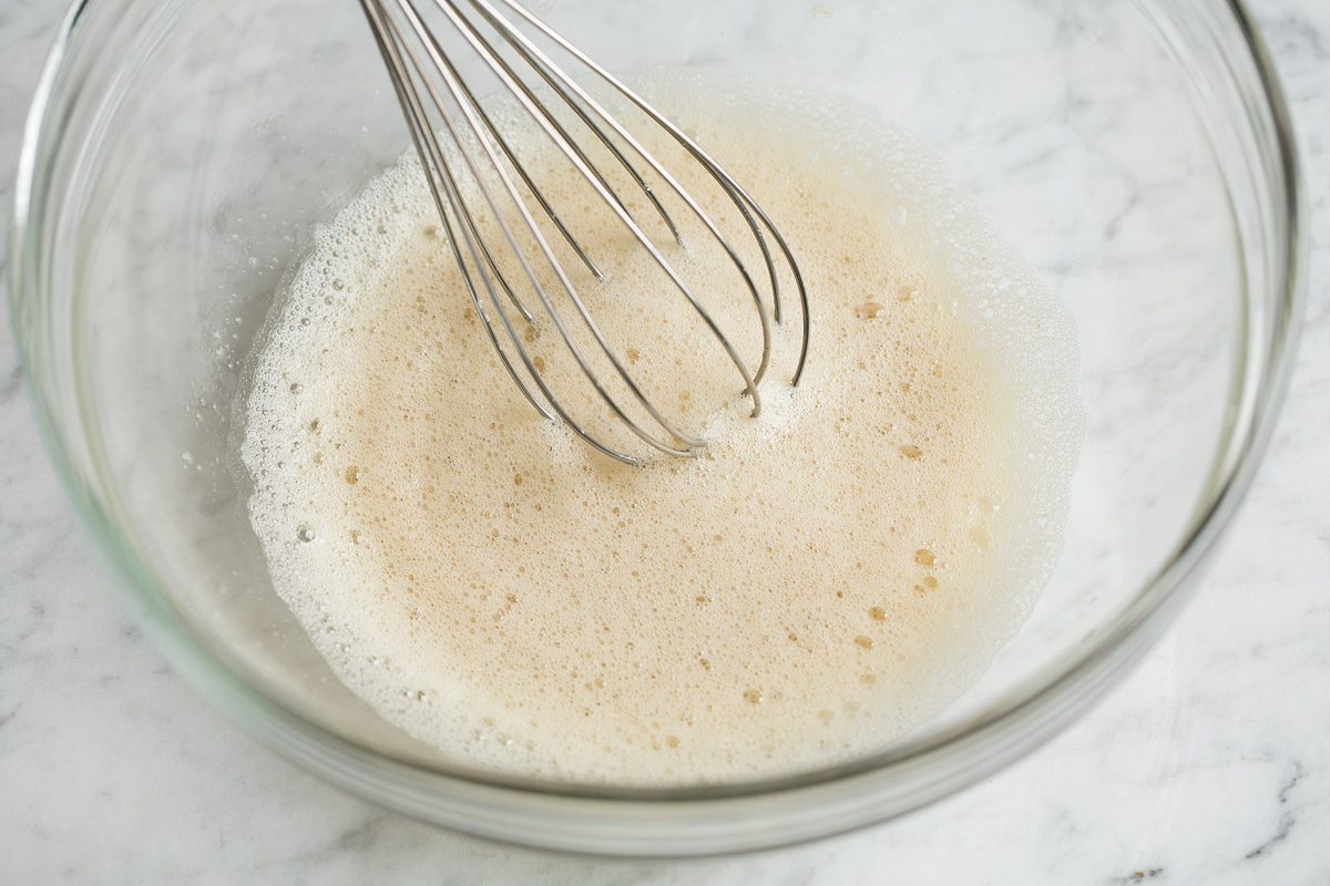 Candied Pecans Frothy egg white mixture in glass bowl.