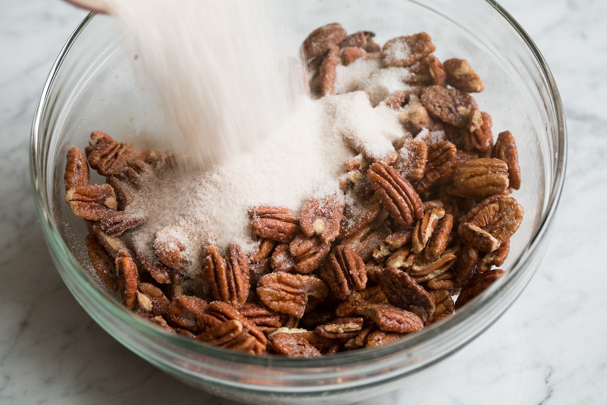 Candied Pecans Adding sugar mixture to egg coated nuts.