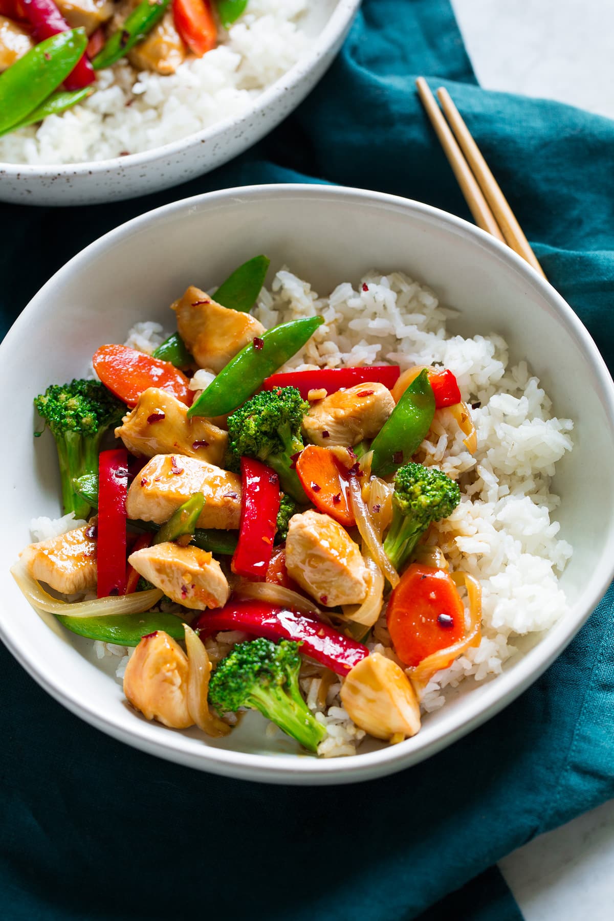 Chicken Stir Fry Chicken and vegetable stir fry on white rice in a bowl.