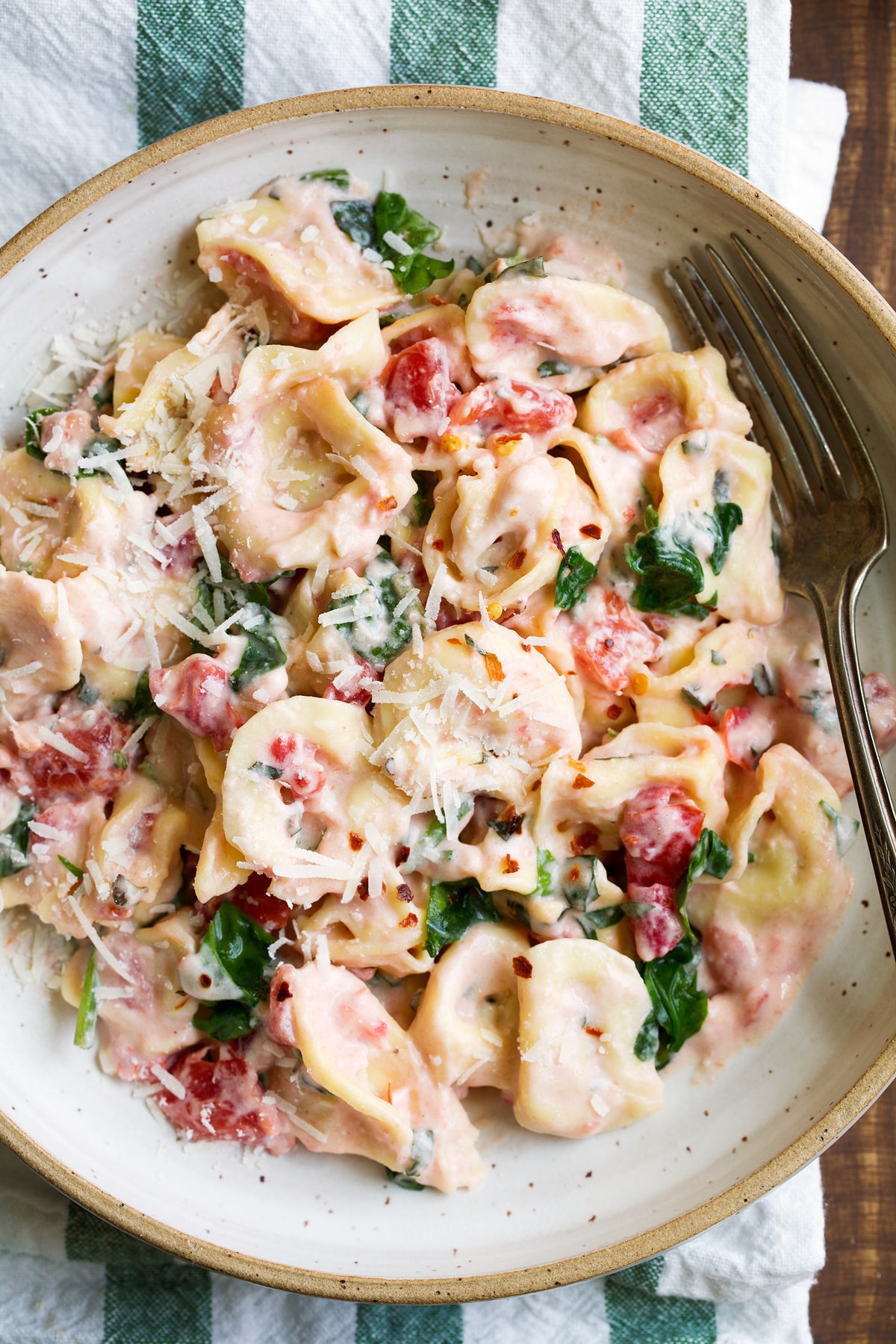 Creamy Spinach Tomato Tortellini Close up image of cheese tortellini covered in a tomato and spinach sauce.