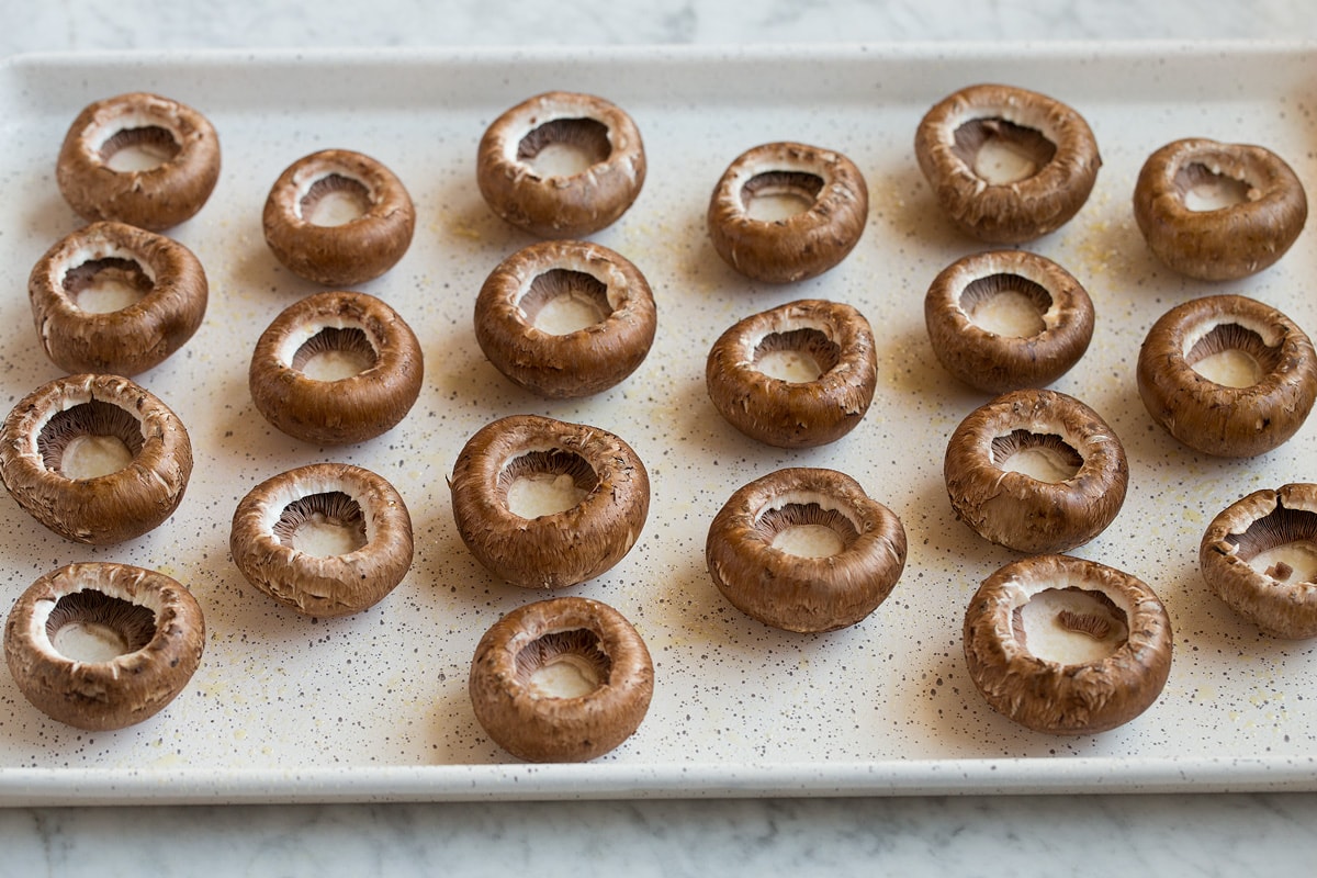 Stuffed Mushrooms Cremini mushroom caps resting upside down on a baking sheet.