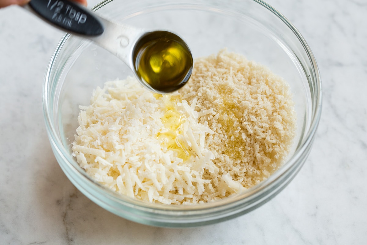 Stuffed Mushrooms Preparing the panko mixture for stuffed mushrooms in a glass mixing bowl and drizzling with olive oil.