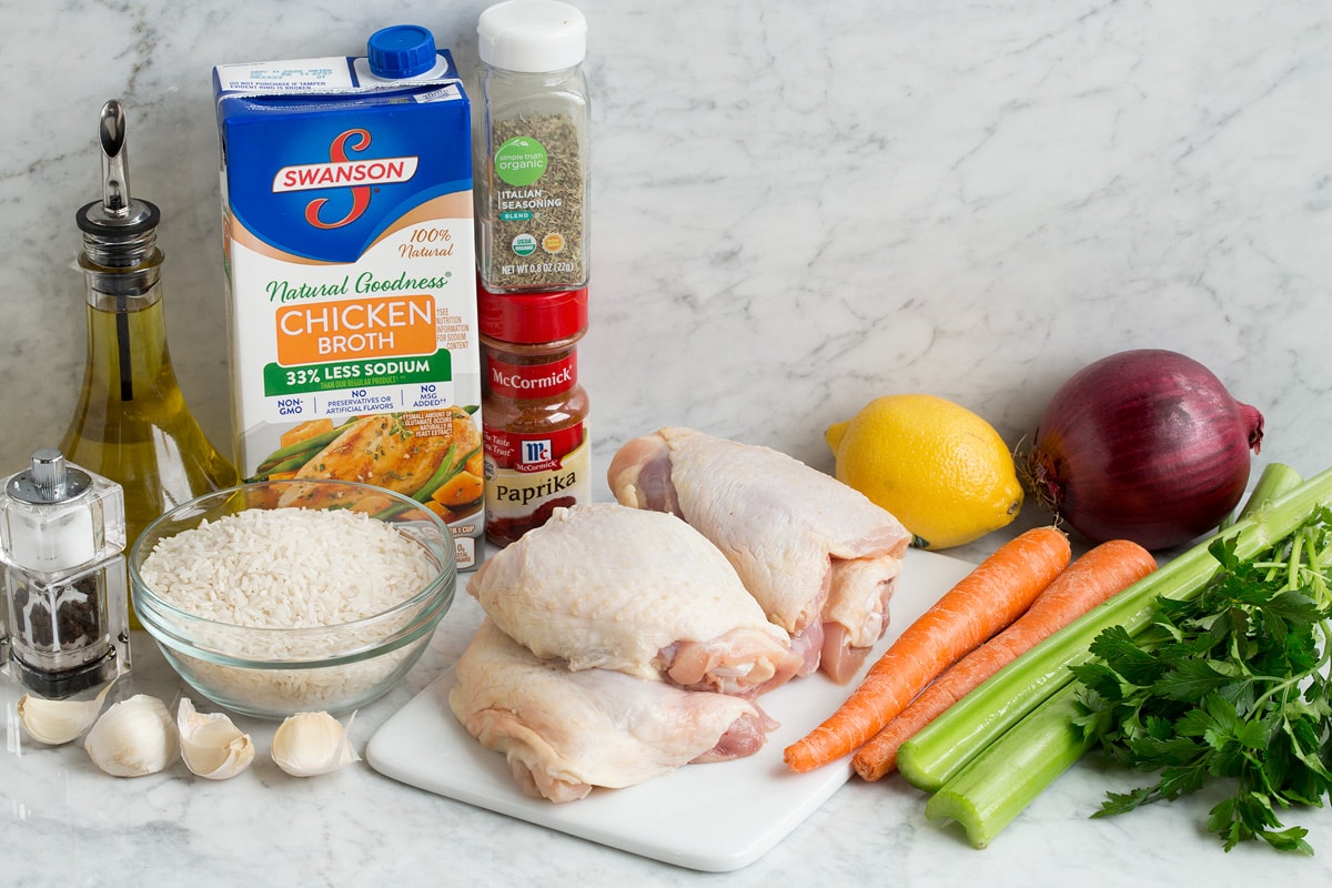 Chicken and Rice Image of ingredients used to make chicken and rice. Includes chicken thighs, rice, fresh vegetables, herbs, oil, lemon, garlic, salt and pepper.