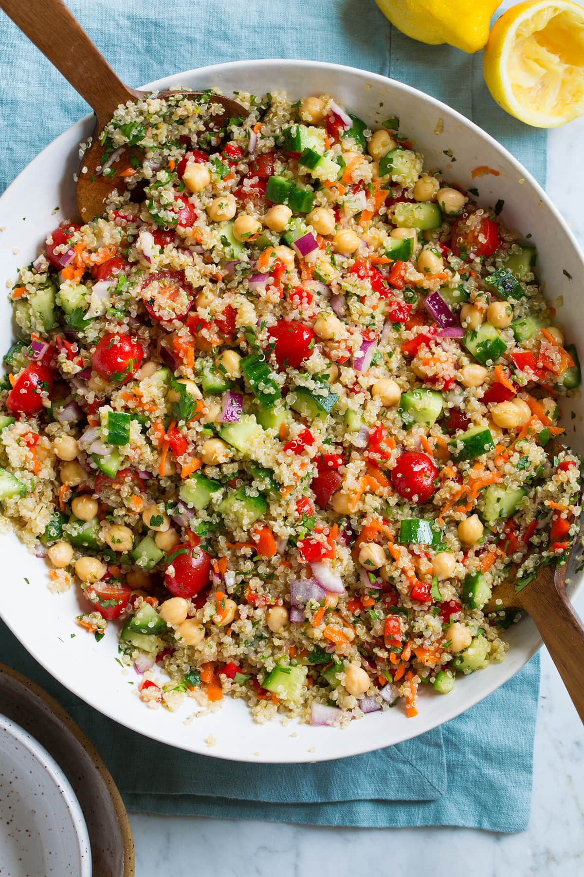 Quinoa Salad Quinoa Salad in a large serving bowl with wooden tongs on the side.