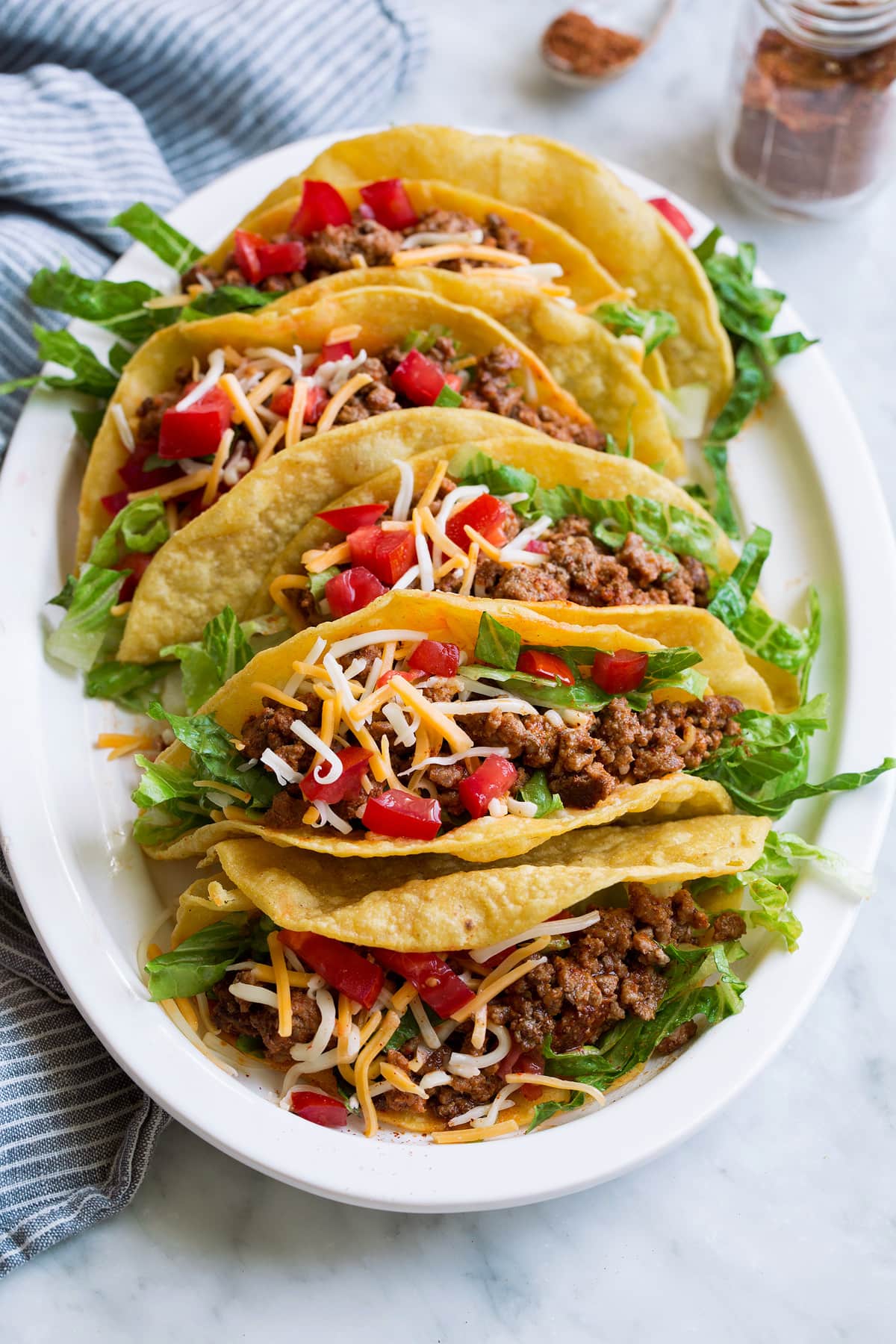 Photo of ground beef tacos on a platter which have been seasoned with a homemade taco seasoning. Showing how to use the DIY taco seasoning.
