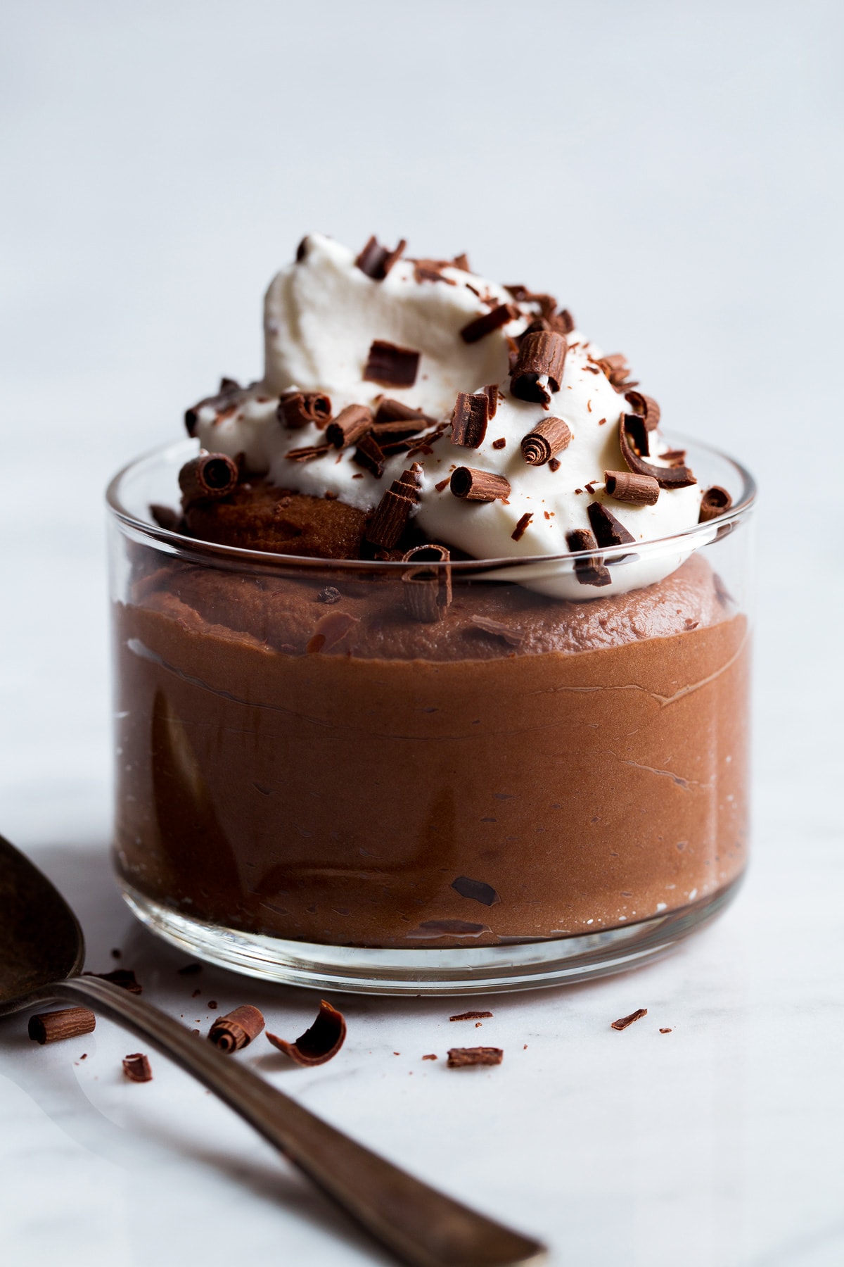 Chocolate Mousse Glass full of chocolate mousse topped with whipped cream and chocolate shavings.