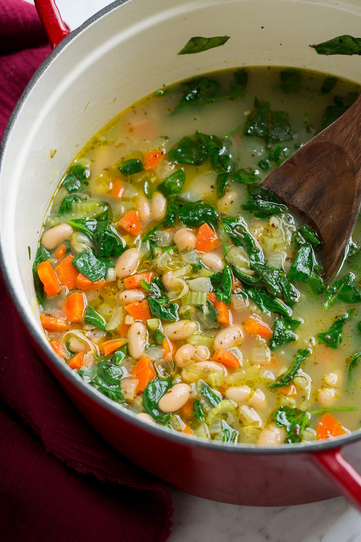 Bean Soup {Tuscan Style} Finished bean soup shown in a large red and white pot.