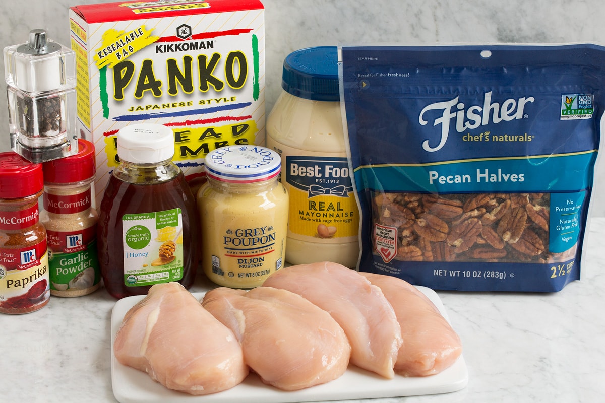 Honey Mustard Pecan Crusted Chicken Image of ingredients used to make honey mustard pecan chicken. Shows pecans, chicken breasts, mayonnaise, dijon mustard, panko, paprika, garlic powder, honey, salt and pepper.