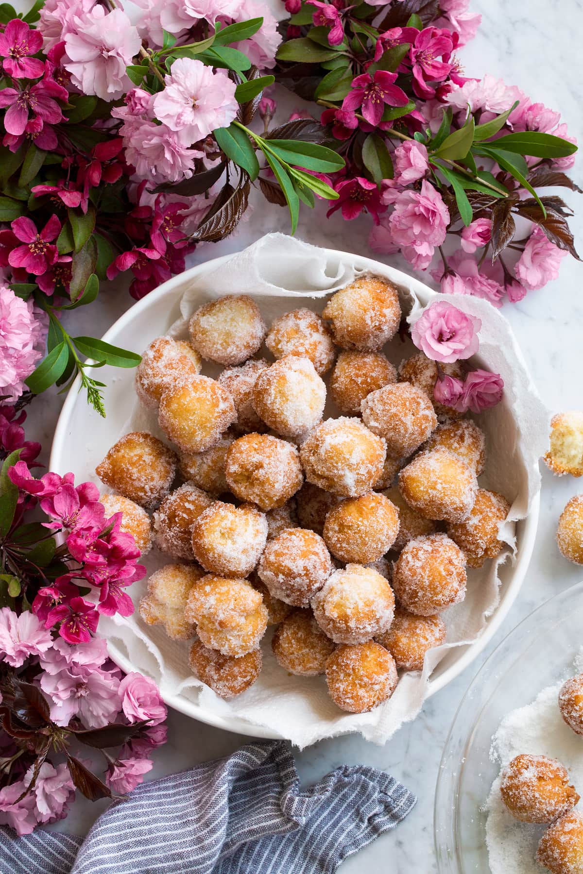 Easy 15 Minute Donuts Donut holes in a bowl surrounded by flowers.