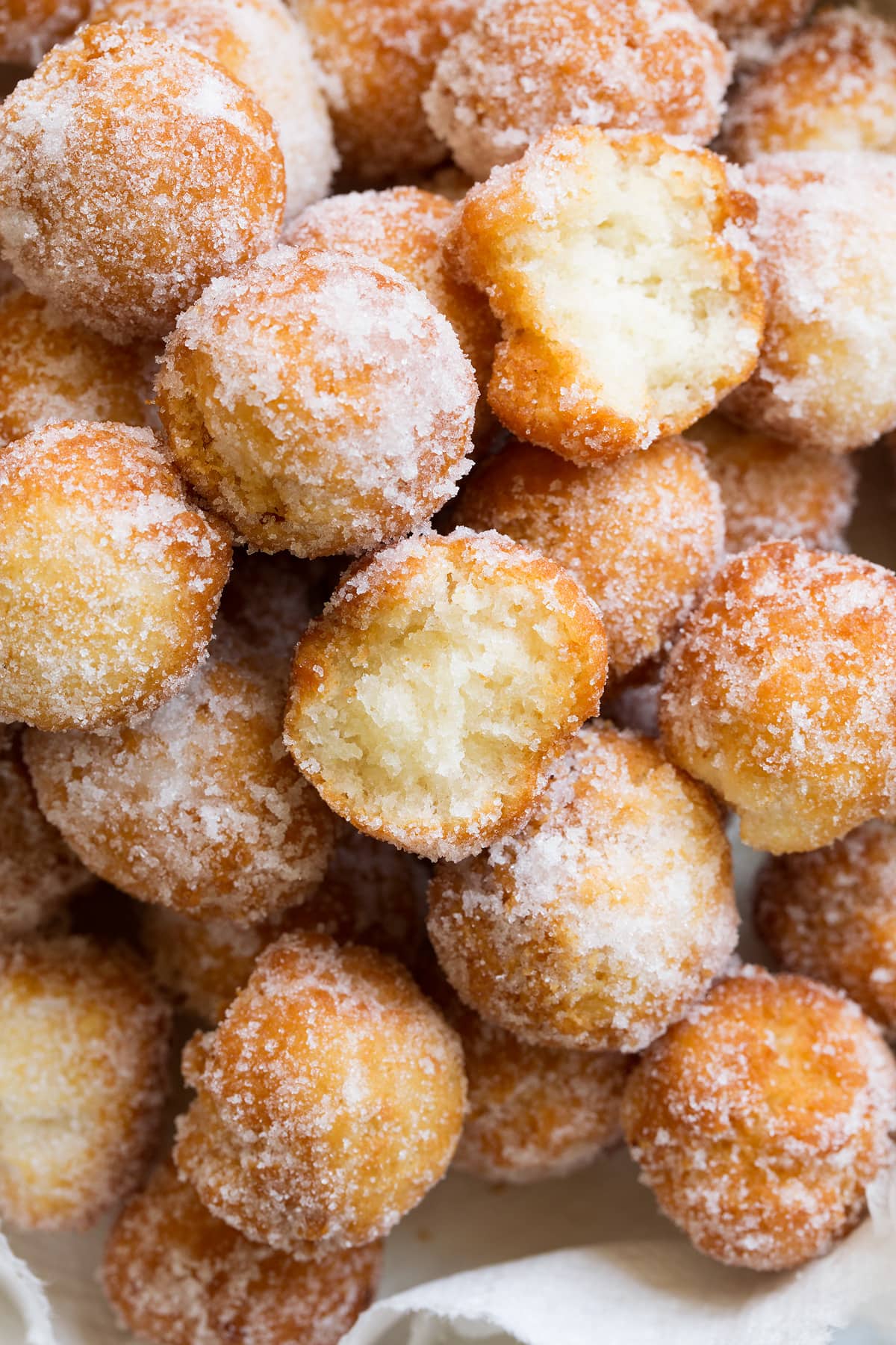 Close up image of donut holes coated in cinnamon sugar.