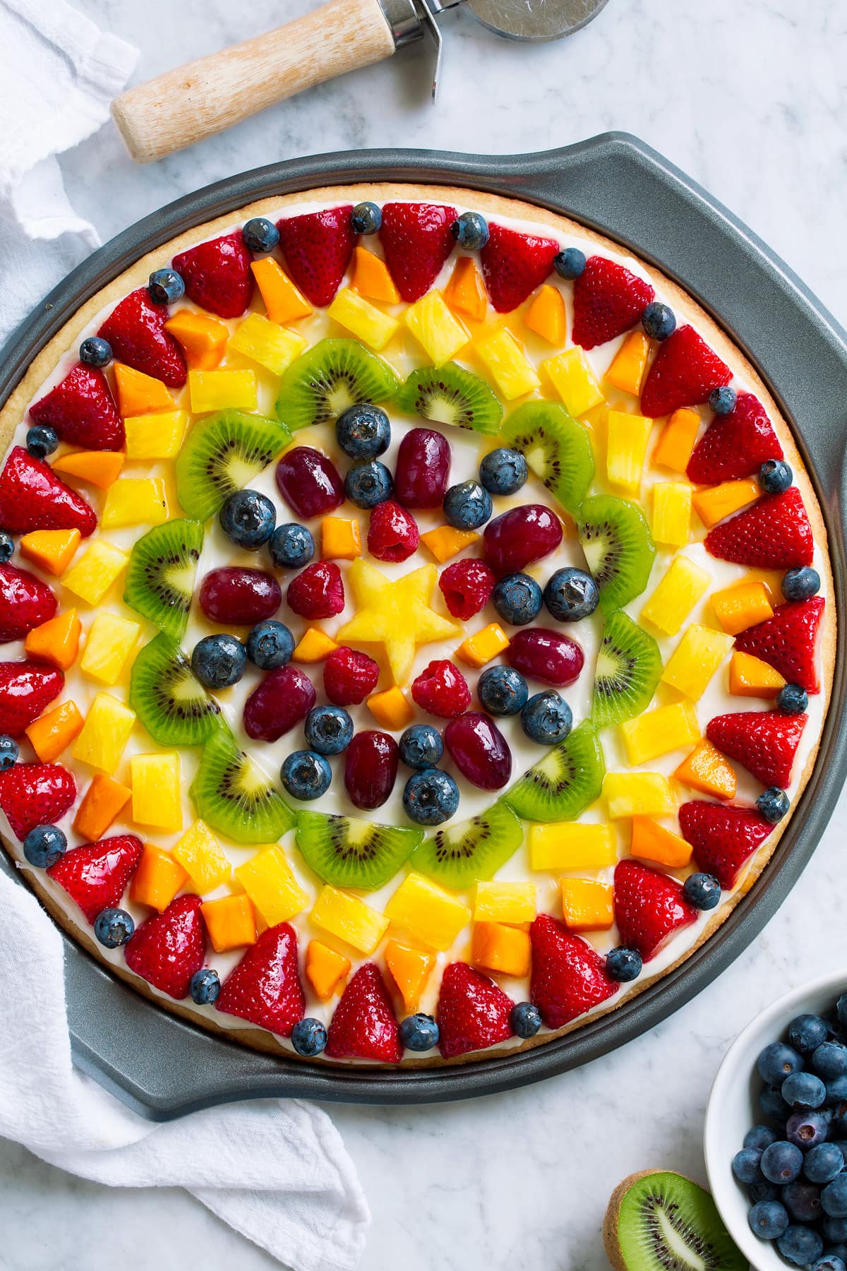 Fruit Pizza Homemade fruit pizza decorated in a artistic pattern with colorful fresh fruit.